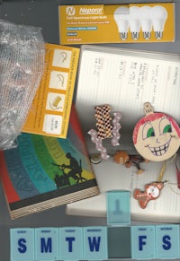 a box containing a notebook, pencils, and other items