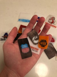 a person's hand holding a bunch of different stickers